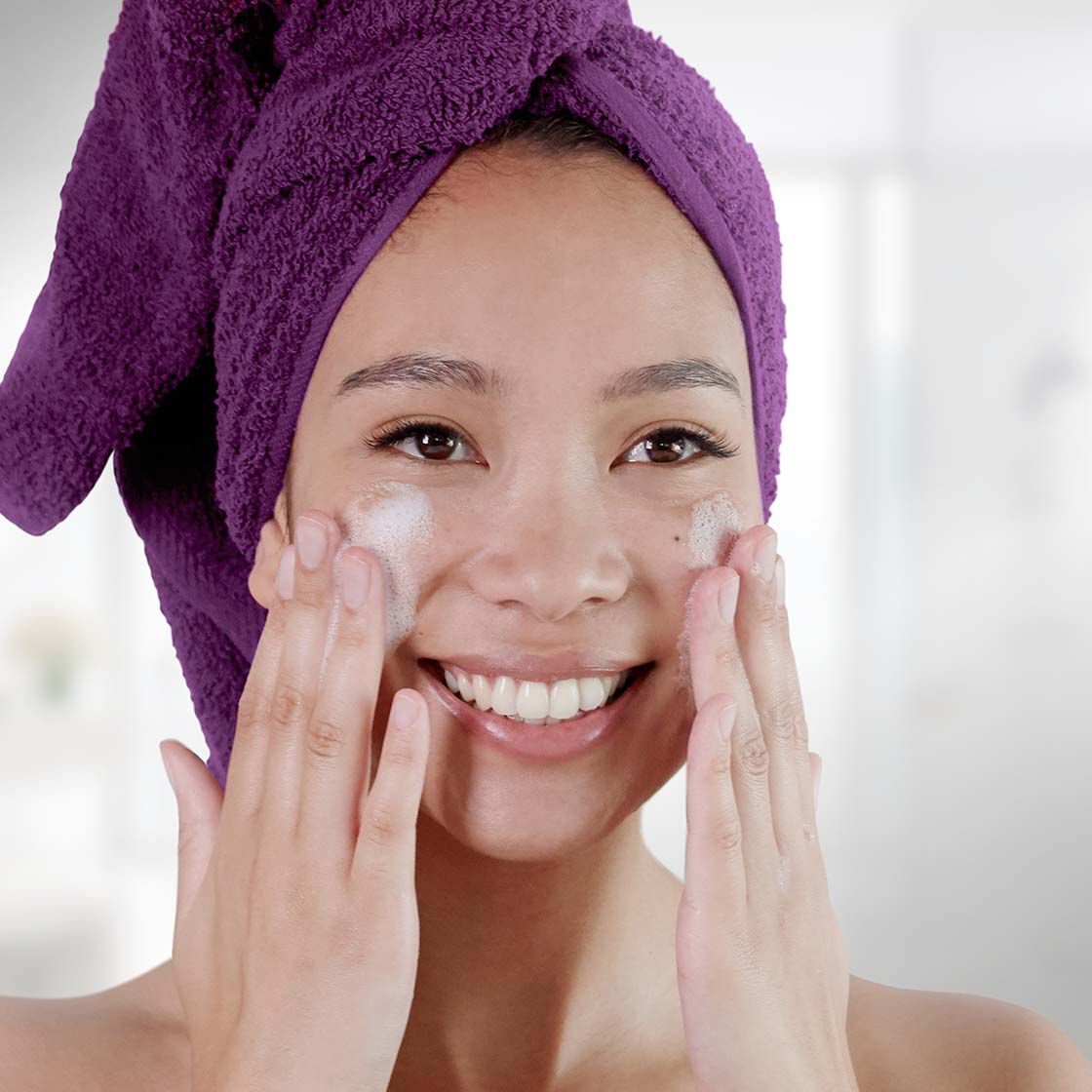 chica lavandose la cara con espuma limpiadora